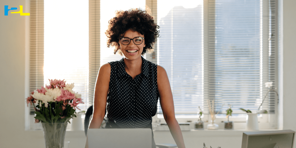 A woman standing in front of a laptop computer.